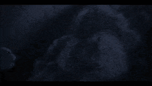 a heart shaped fireball is coming out of the ground in the dark .