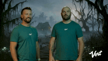 two men standing next to each other wearing green shirts that say " vert "