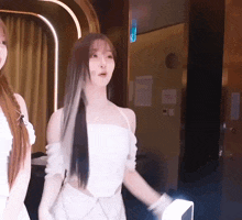 two women are standing next to each other in a room with a sign on the wall that says exit