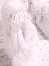 a woman in a white dress is sitting on a bed with her head in her hands .