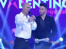 two men standing on a stage with the word valentina behind them