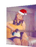 a woman wearing a santa hat is sitting on a bed playing a guitar