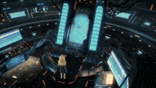 a girl stands in a futuristic room with a large screen that says ' ii ' on it