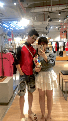 a man and a woman taking a picture in a store
