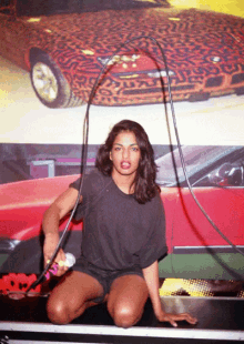 a woman is kneeling down in front of a leopard print car