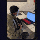 a man sitting at a desk with a laptop that says ubuntu on it