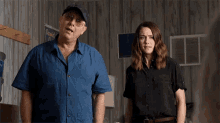 a man and a woman stand in a room with a sign that says david