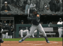 a baseball player is swinging at a pitch in front of a wall that says milwaukee astros
