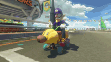 a cartoon character is riding a yellow vehicle in front of a sign that says super mario