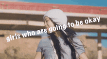 a woman wearing a hat and a t-shirt with the words girls who are going to be okay on the bottom