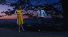 a woman in a yellow dress and a man in a white shirt are dancing