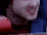 a blurry picture of a man 's face with a red glove on