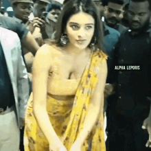 a woman in a yellow dress is standing in a crowd of people .