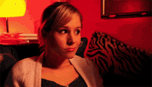 a woman sitting in front of a zebra print couch