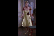 a woman in a white and yellow dress is standing in a room .