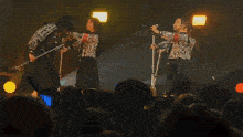 a group of girls singing into microphones in front of a crowd of people