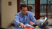 a man sits at a table with a plate of food and a radio on it