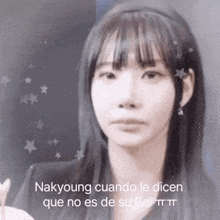 a woman with long hair and bangs is looking at the camera with a caption .