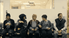 a group of people sitting in a waiting room with a sign that says w