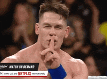 a wrestler is making a shhh sign with his finger to his mouth