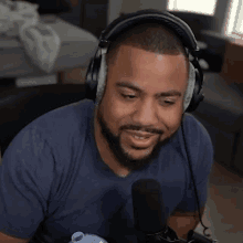 a man wearing headphones and a blue shirt is smiling