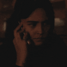a woman with a ring on her finger talks on a cell phone