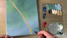 a person is painting on a canvas with the words made in animotica behind them