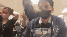 a man wearing glasses and a gap sweatshirt is giving the middle finger