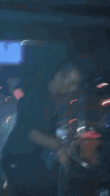 a blurry picture of a man in a dark room with a sign in the background that says ' playstation '