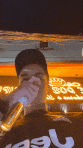 a man is holding a microphone in front of a sign that says ' 200 ' on it