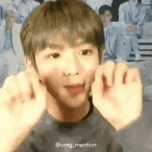 a young man is making a face with his hands .