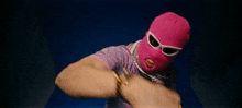a man wearing a pink hat and a gucci shirt is making a funny face