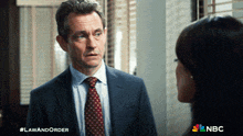a man in a suit and tie is talking to a woman in a law and order advertisement