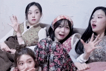 a group of girls are sitting on a couch and one of them is wearing a head scarf