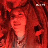 a close up of a woman 's face against a red background .
