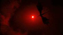 a dragon is flying through a red sky with the sun behind it