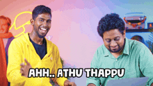 a man in a yellow jacket is laughing next to another man in a green shirt who says ahh.. athu thappu