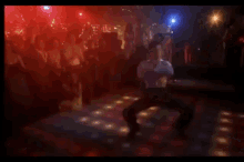 a man is dancing on a dance floor in front of a crowd of people