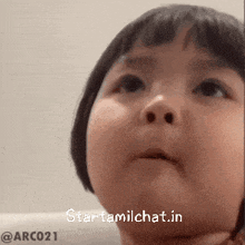 a little girl with short hair is looking up with the words starttamilchat.in above her
