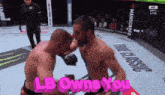 two men are fighting in a boxing ring with the words " lb owns you " in pink