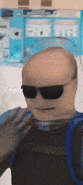 a bald man wearing sunglasses and a vest has a viggle.ai sticker on the bottom right