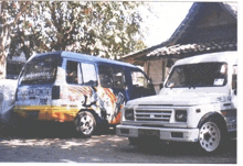 a blue van with the word punk on the side is parked next to a white van