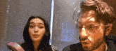 a man and a woman wearing glasses are looking at each other