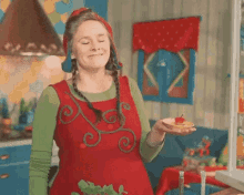 a woman in an elf costume is holding a piece of food and says ah que demais