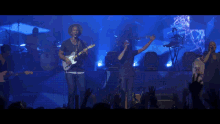 a crowd of people raising their hands in the air at a concert