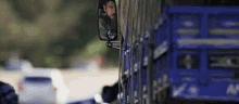 a man with a beard is driving a blue truck .