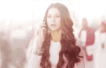a woman with long red hair is talking on a cell phone .