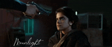 a man is pointing a gun at a woman with the word moonlight written below him