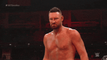 a man without a shirt is standing in front of a screen that says nxt deadline on it