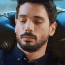 a man with a beard is sleeping in a chair